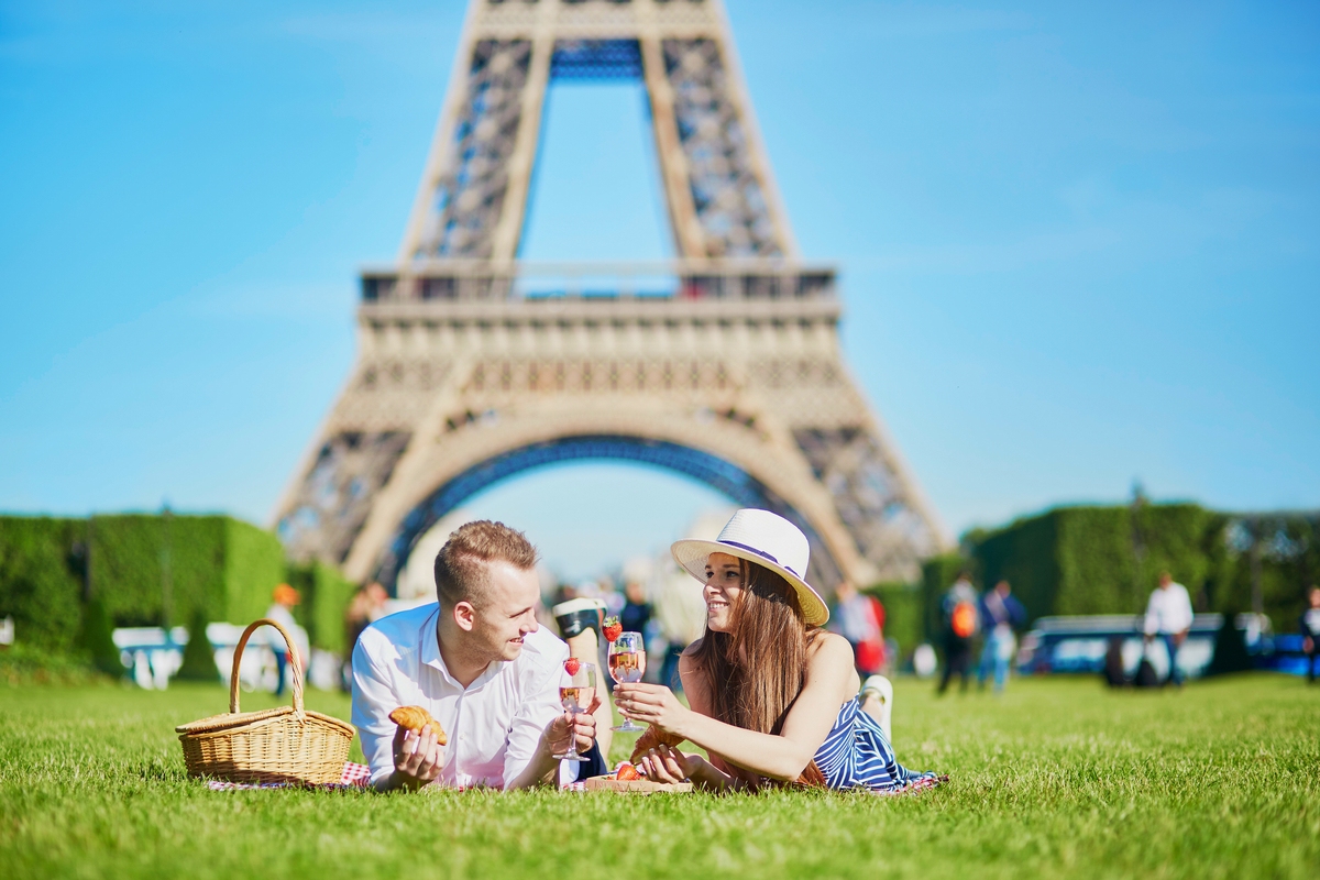 Couple enjoy picnic near Eiffel Tower in Paris France Bastille Day