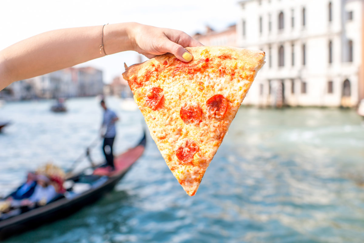 Woman holding pizza in Venice food bucket list